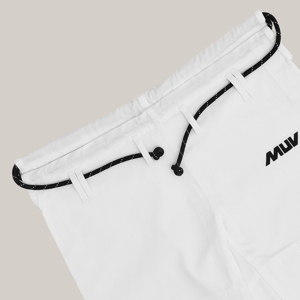 Engine Gi trousers laid at an angle, showing the drawstring and MUV hip logo