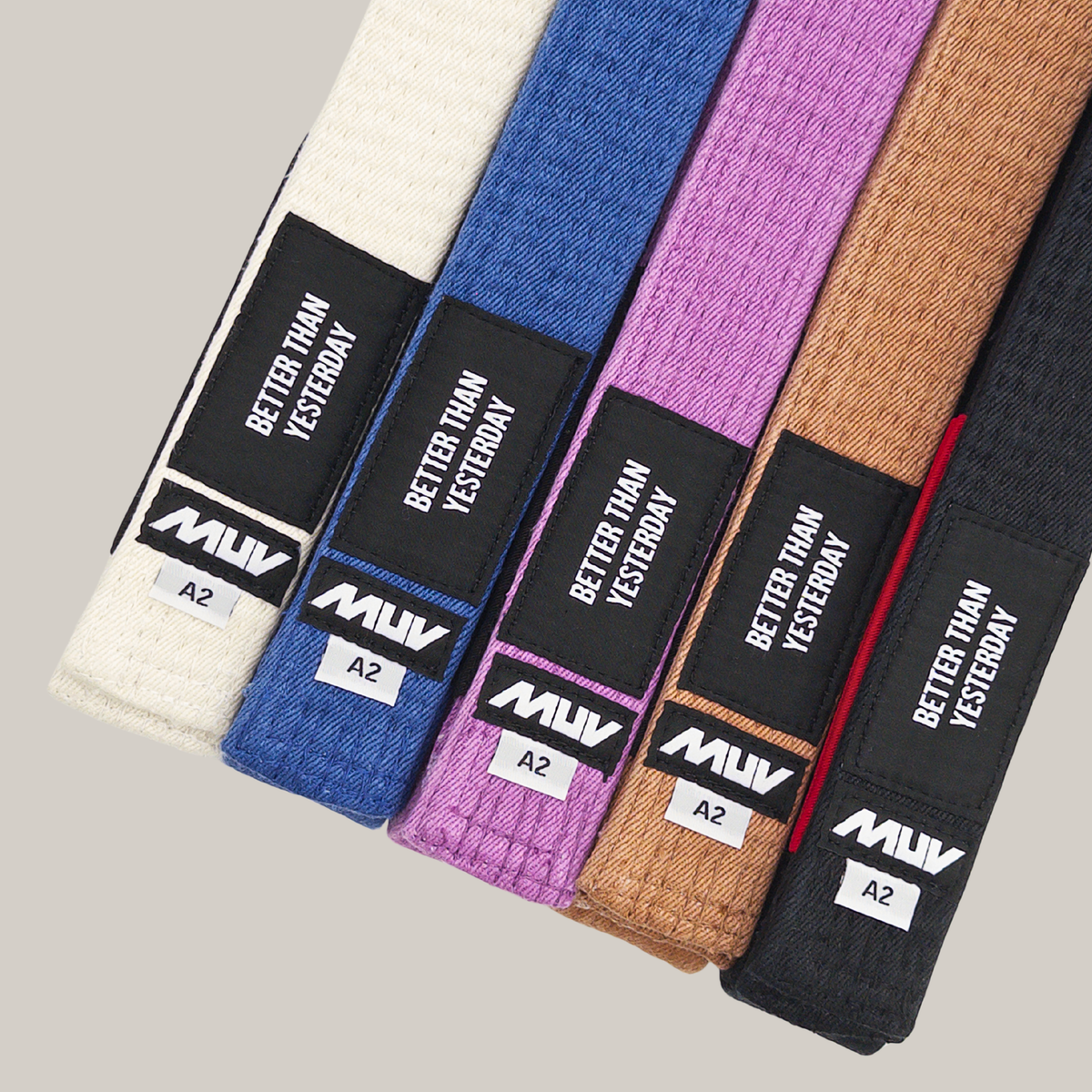MUV Relic Belts in white, blue, purple, brown and black, laid side by side showing the woven labels